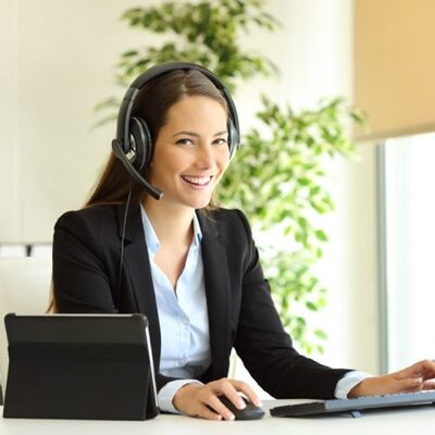 Happy tele marketer working looking at camera at office